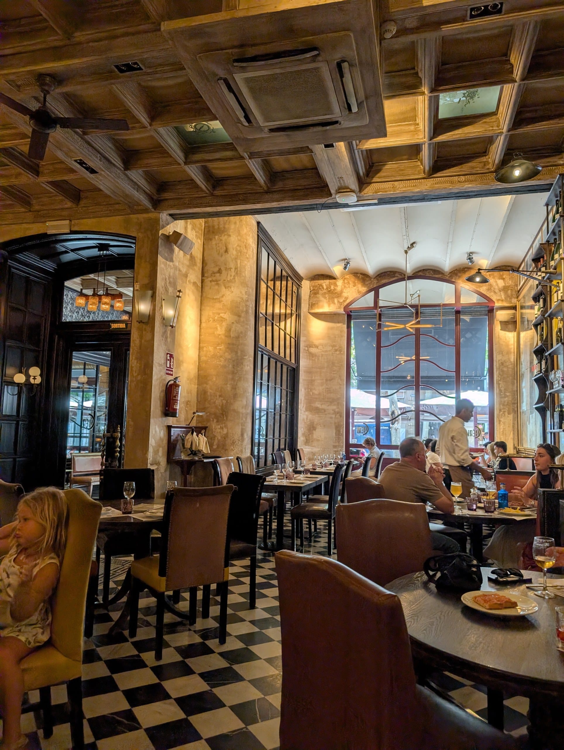 The checkerboard tiled floor and banquettes at Cheri Barcelona