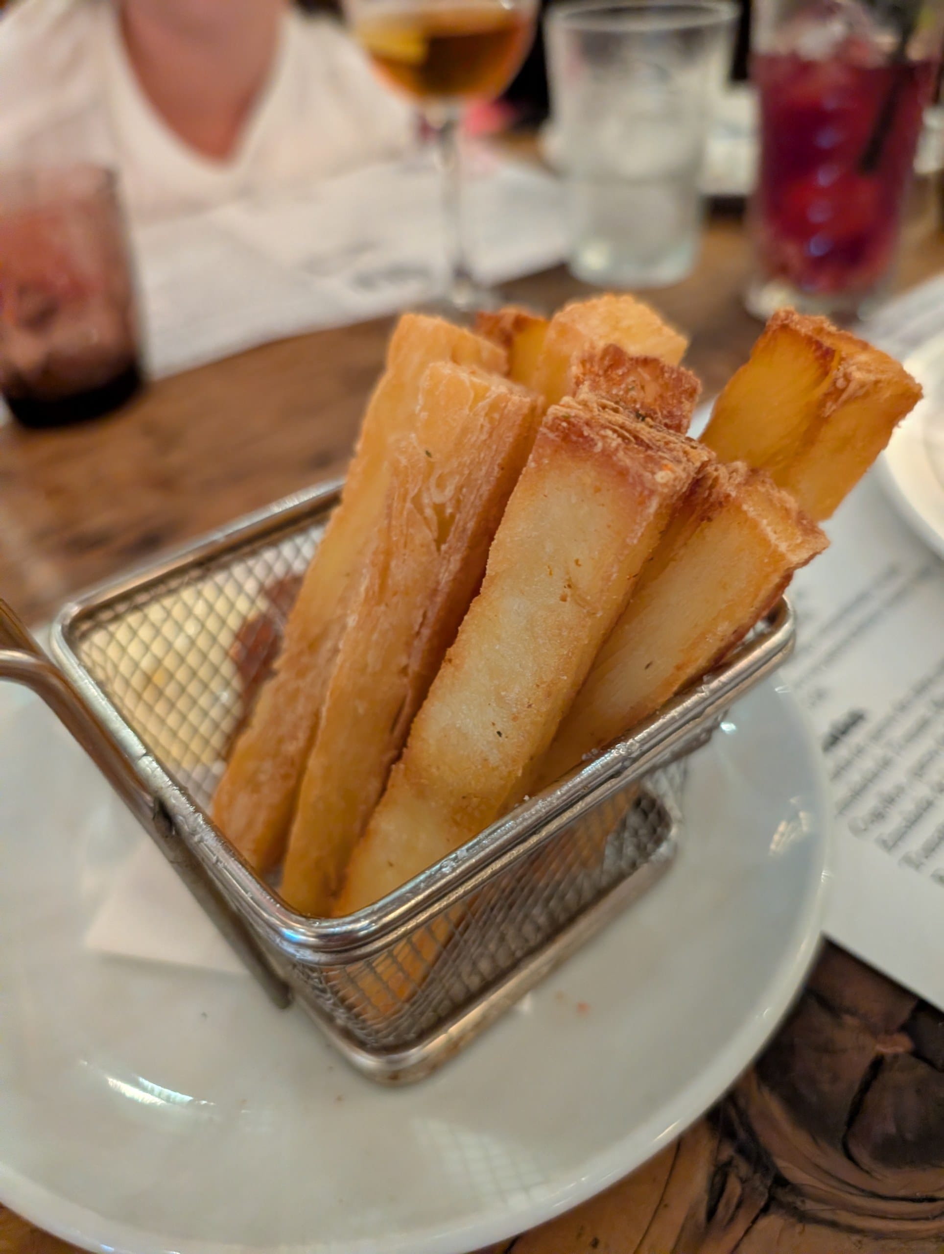 Fried rolls served in a wire basket at Cheri Barcelona