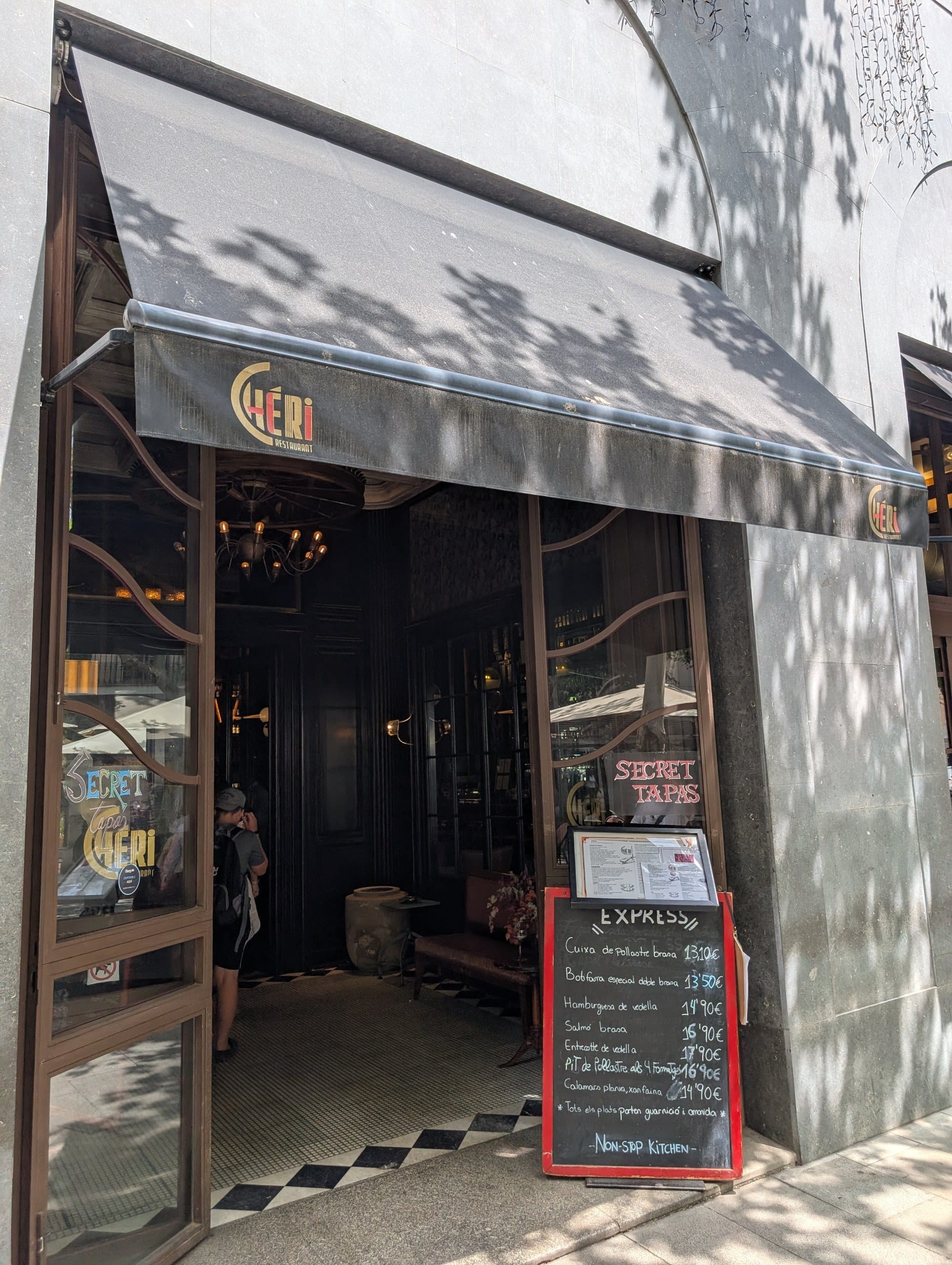 The Cheri restaurant awning on Enric Granados with the Secret Tapas sign in the window