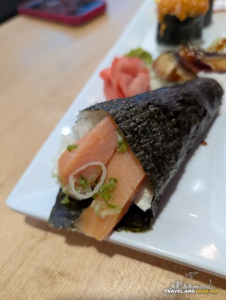 The Philadelphia at e Sushi, ordered as a hand roll: smoked salmon and cream cheese in a nori cone with scallion and raw onion.