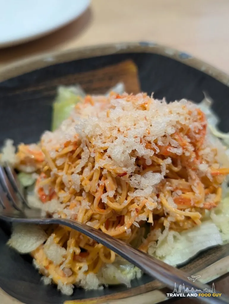Close up on the spicy kani salad at e Sushi, where the tempura crunch has soaked into the dressing rather than sitting crisp on top.
