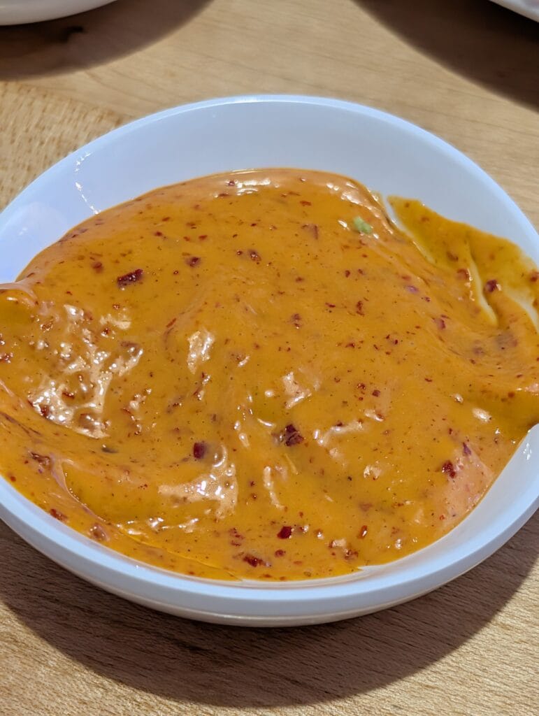 A side bowl of the spicy mayo at e Sushi, a dressing style sauce rather than the usual sriracha and Japanese mayonnaise mix.