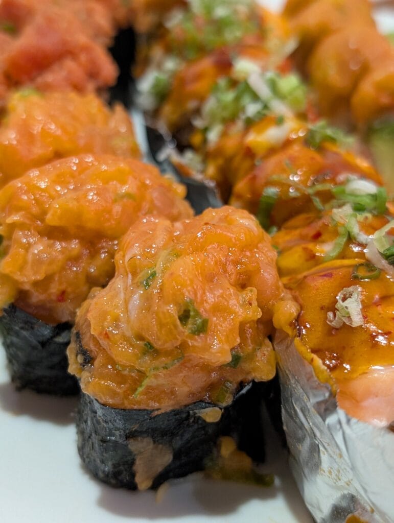 The spicy salmon gunkan at e Sushi, minced rather than chopped, mounded over rice in a nori collar.