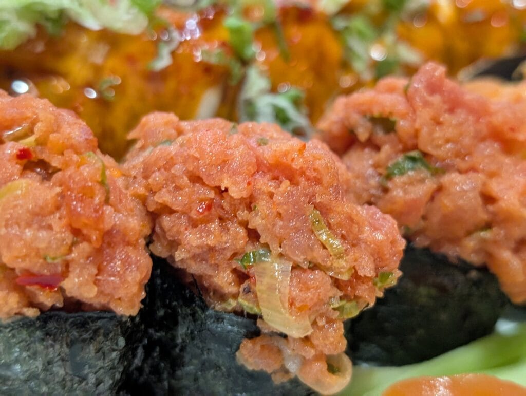 Spicy tuna gunkan at e Sushi, the fish minced fine and flecked with chili and scallion.
