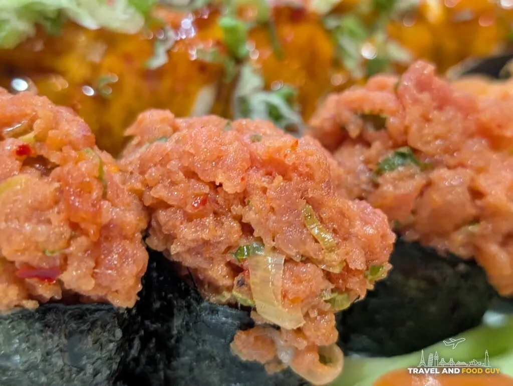 Spicy tuna gunkan at e Sushi, the fish minced fine and flecked with chili and scallion.