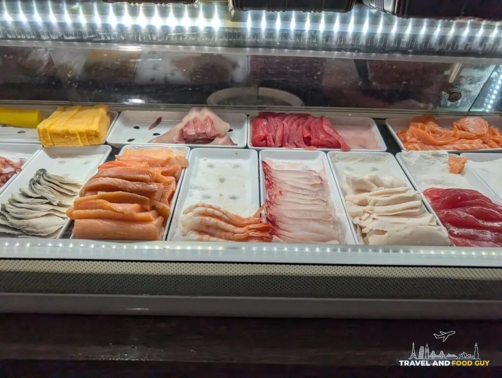 The chilled case behind the sushi bar at e Sushi, with trays of tamago, white tuna, tuna, salmon, mackerel, shrimp, red snapper and squid.
