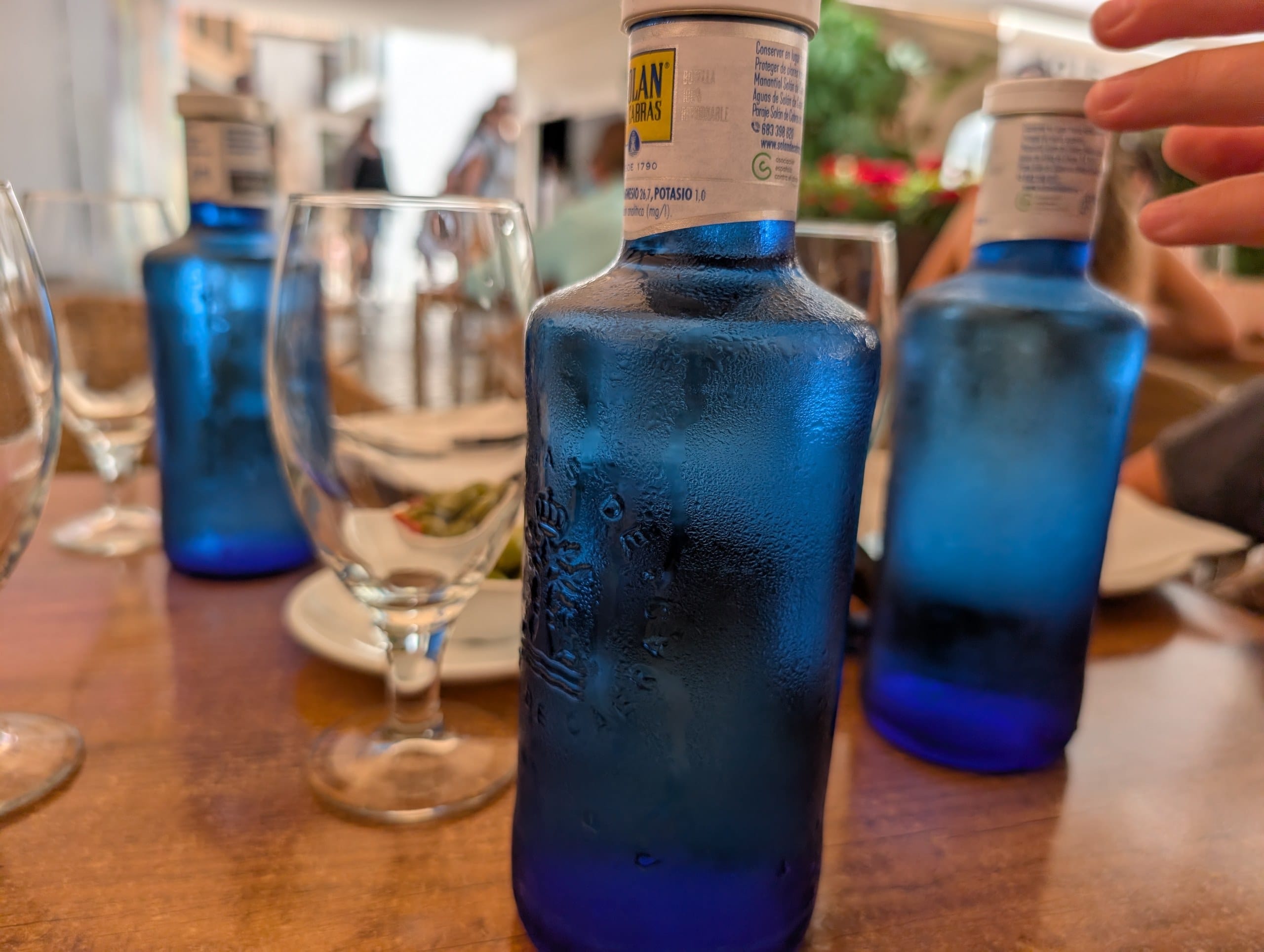 Blue bottles of still water on the table at El Pimpi in Málaga