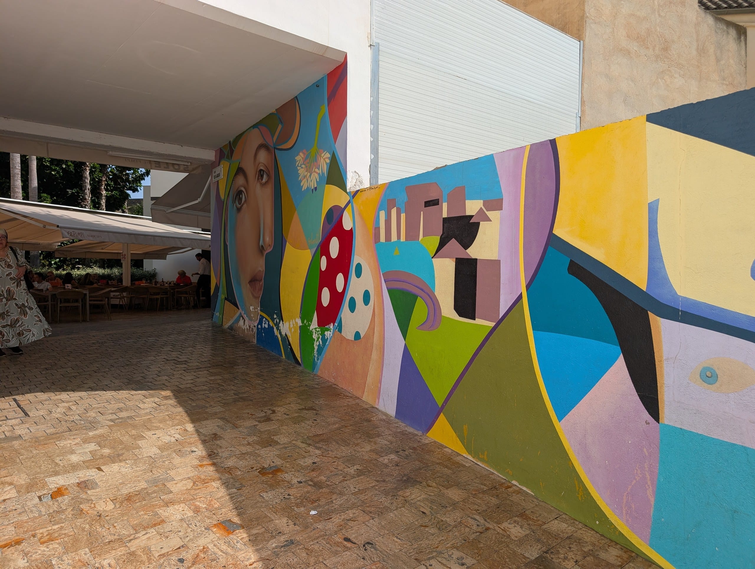 Colorful cubist style mural on the wall leading out to the El Pimpi terrace in Málaga