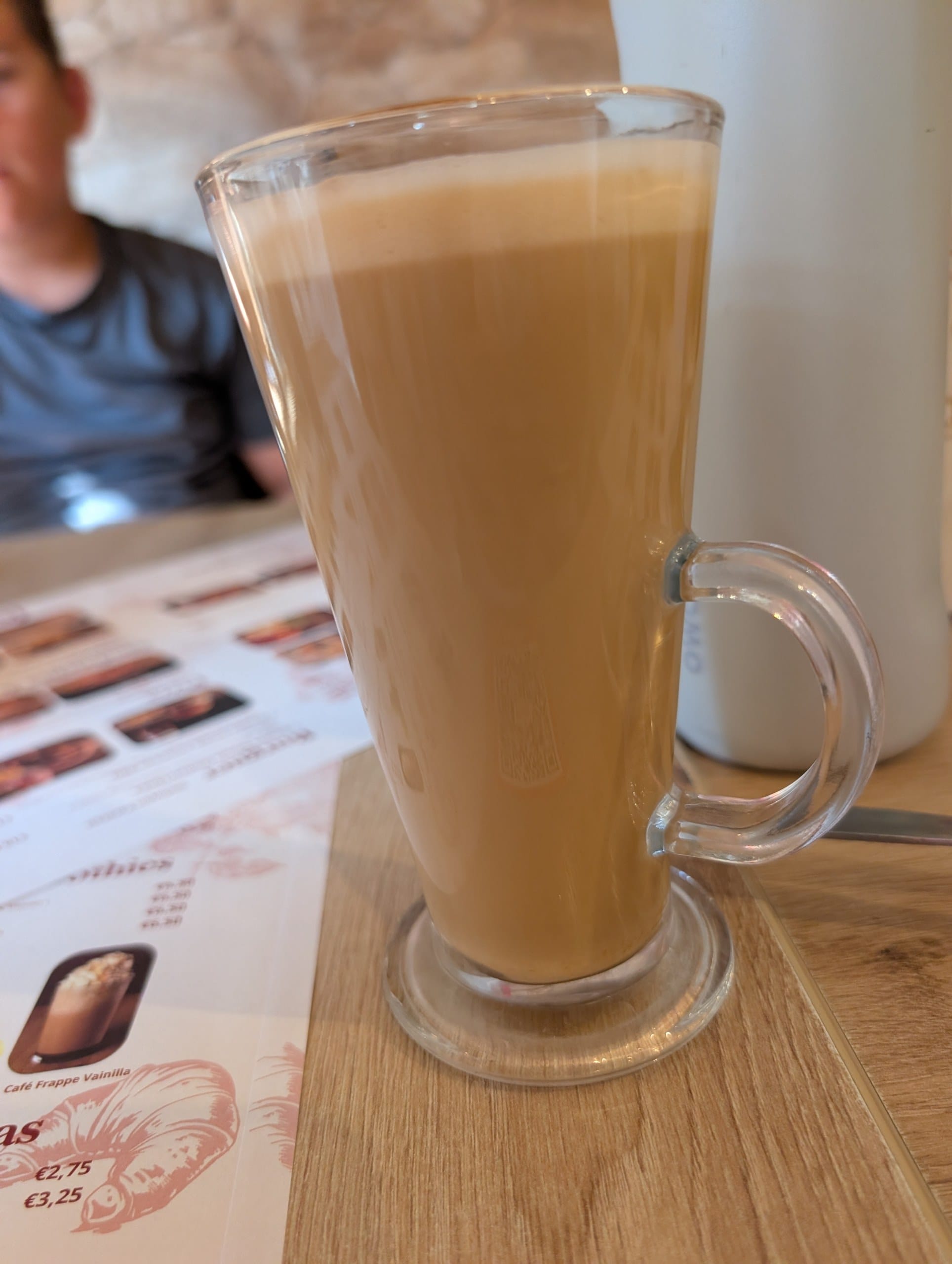A tall glass cappuccino on the table at Ferretti Poble Nou