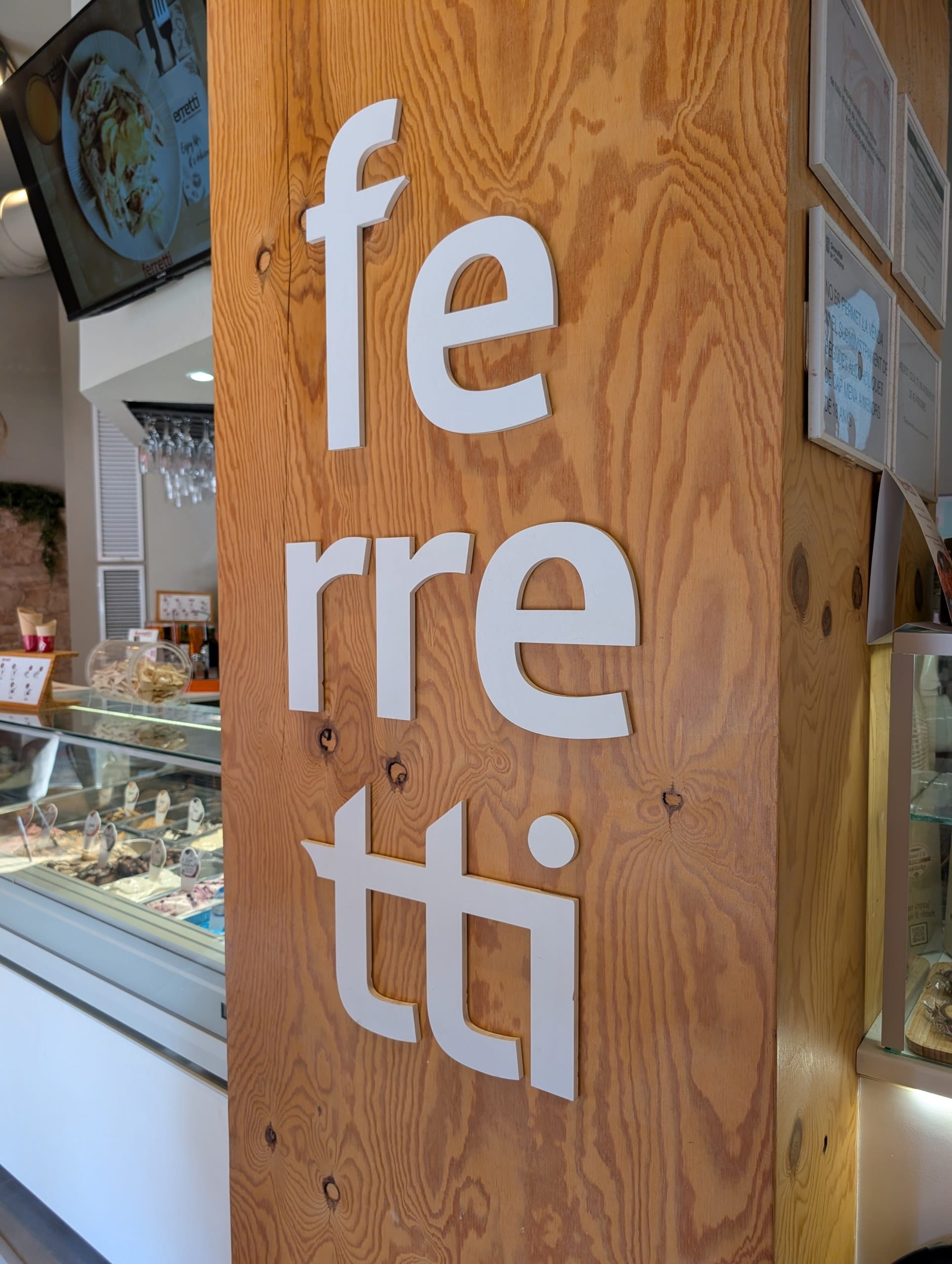 The Ferretti wordmark on a timber column beside the gelato case