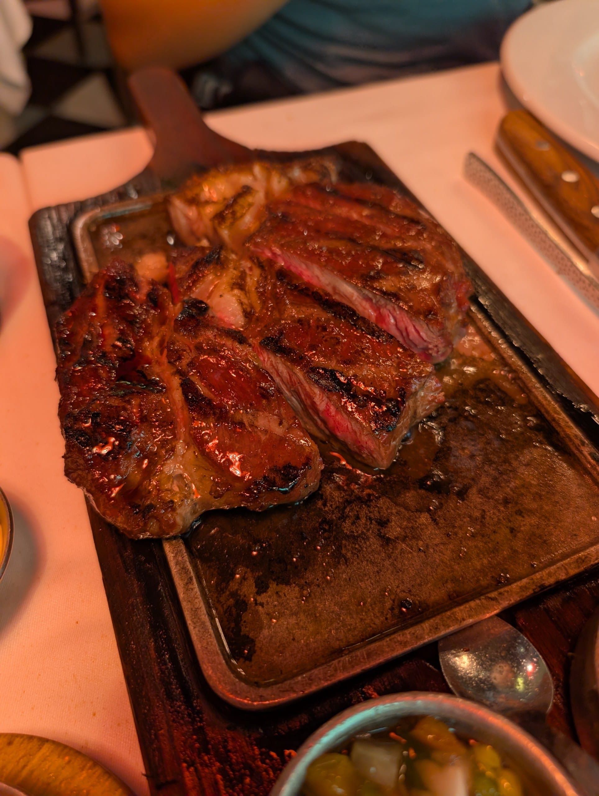 The bife de chorizo at La Cabrera Barcelona still cooking on the cast iron plate it is served on