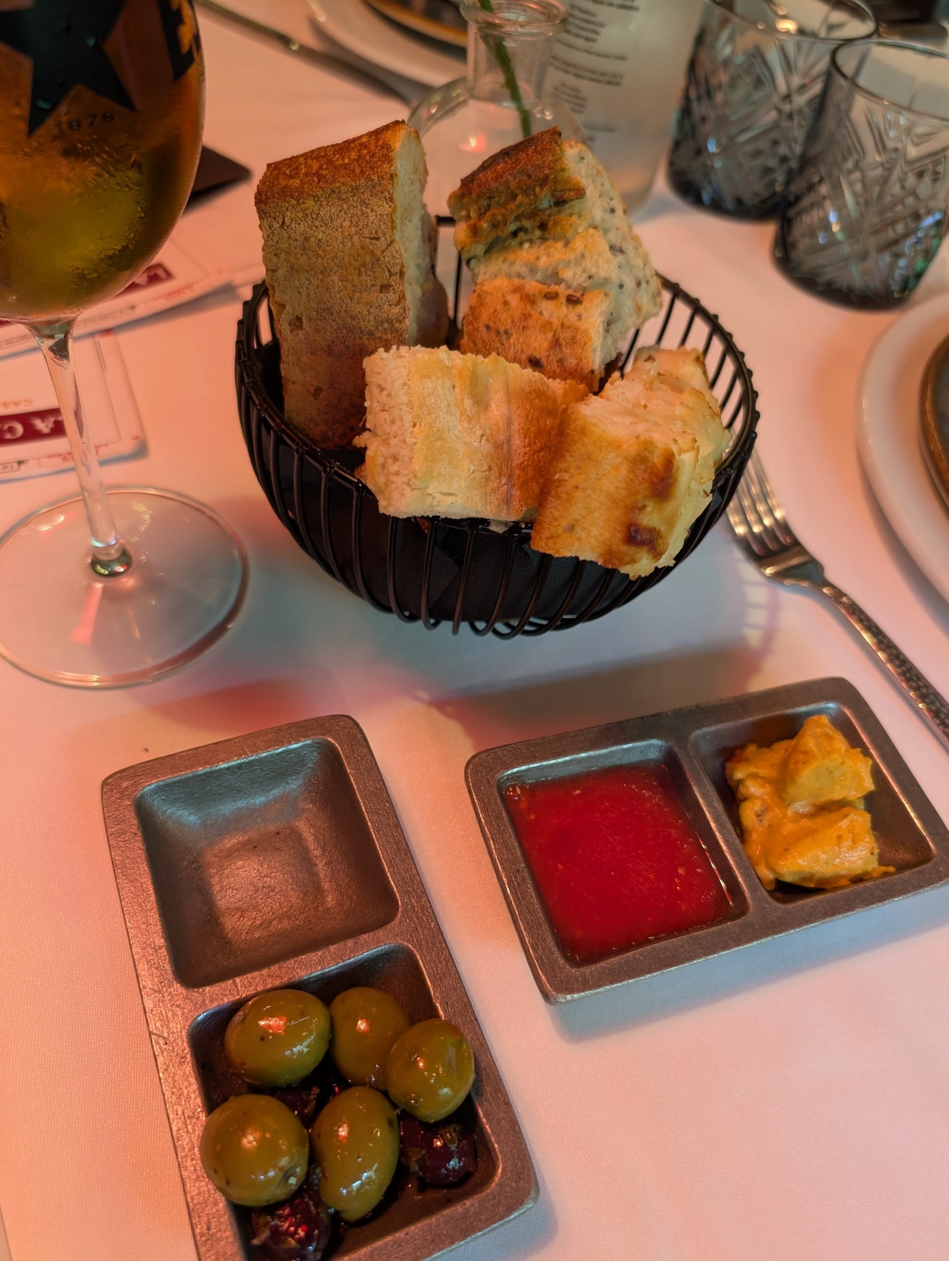The bread basket at La Cabrera Barcelona with olives, a tomato dip and seasoned butter