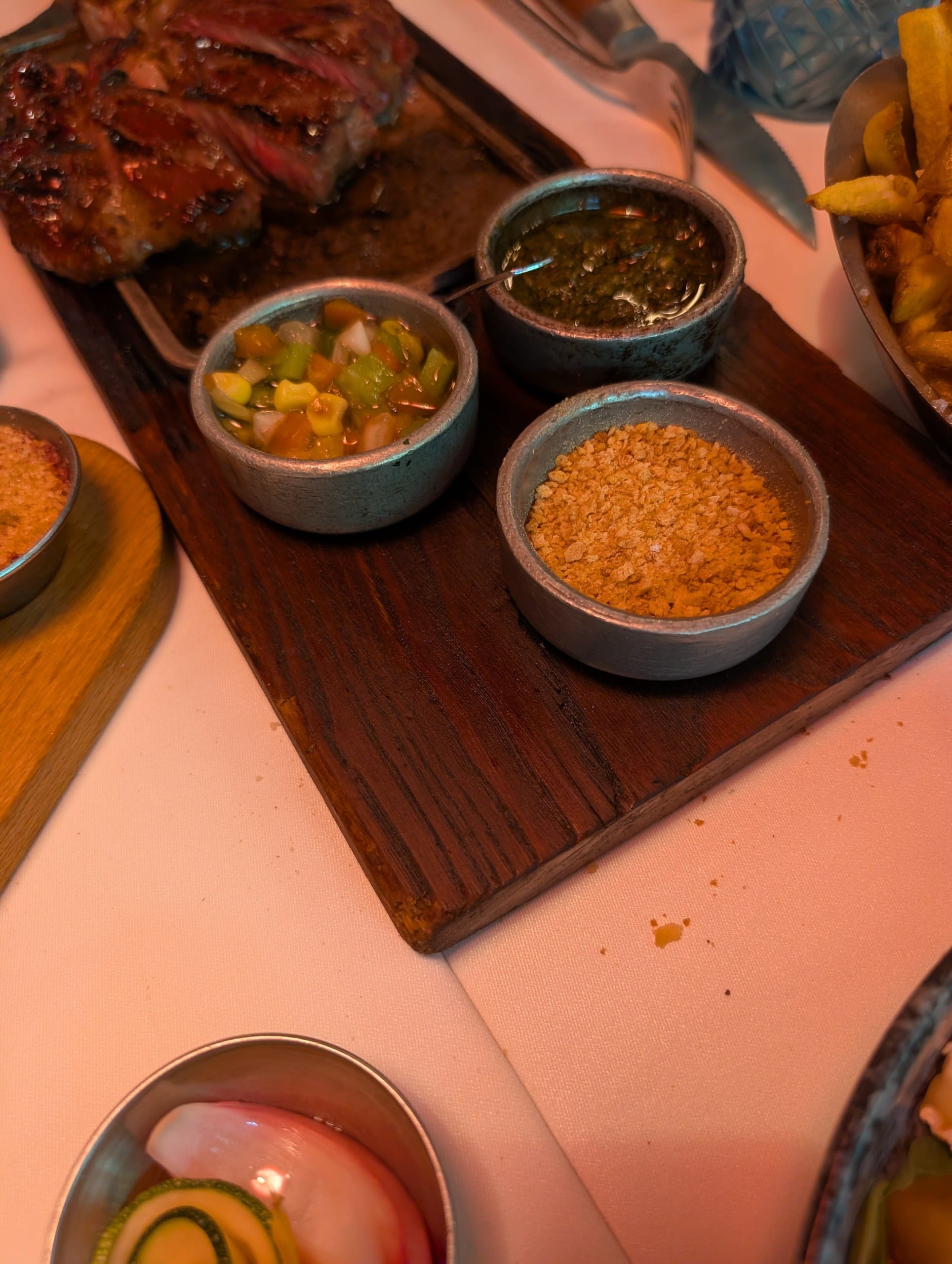 Chimichurri and two more condiments served on the board with the steak at La Cabrera Barcelona