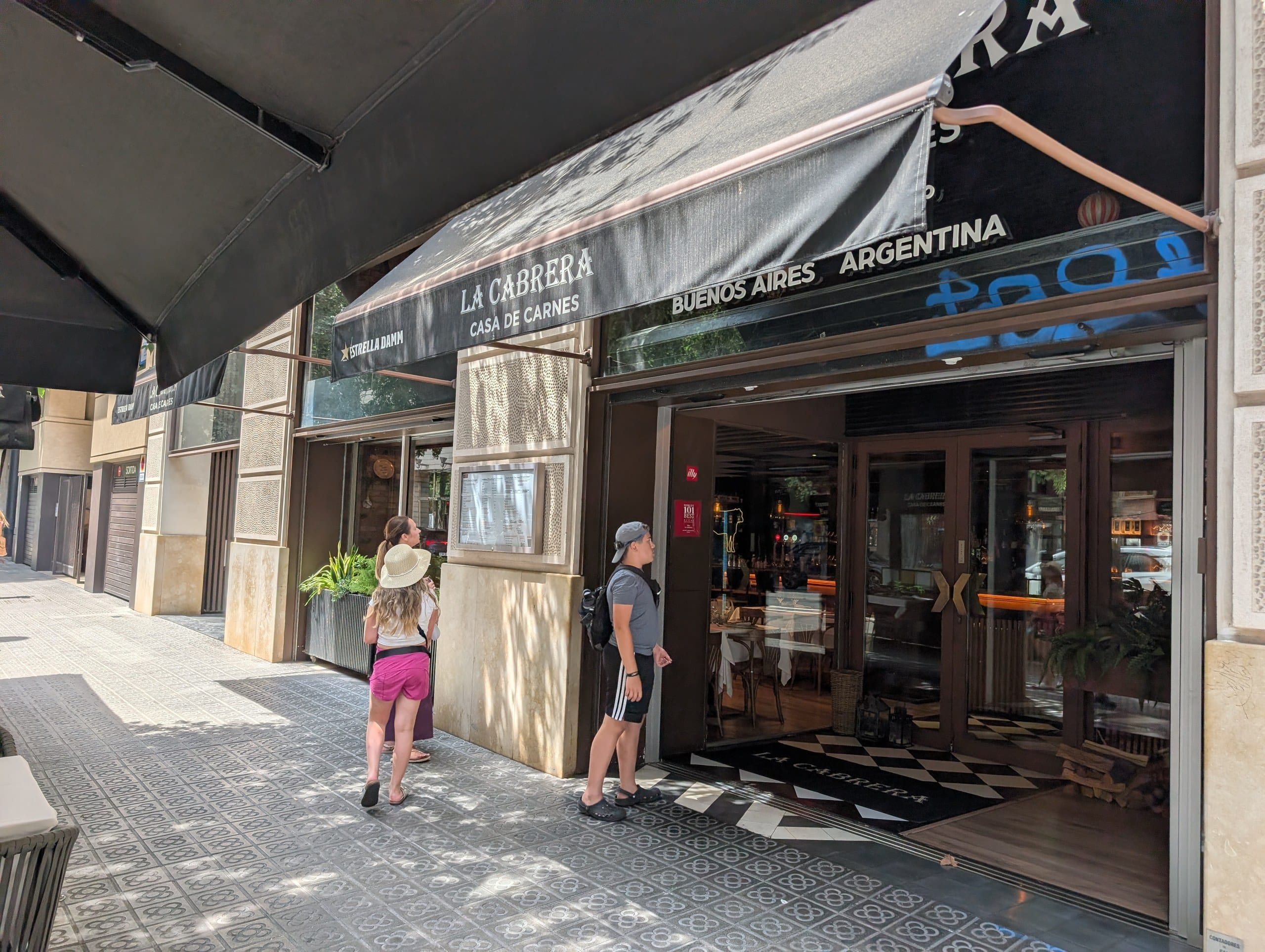 The open front door at La Cabrera Barcelona with Buenos Aires Argentina lettering on the awning