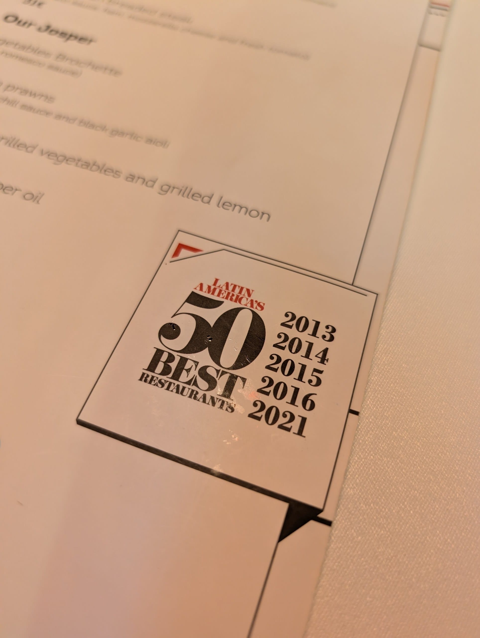 The Latin Americas 50 Best Restaurants badge printed on the La Cabrera Barcelona menu
