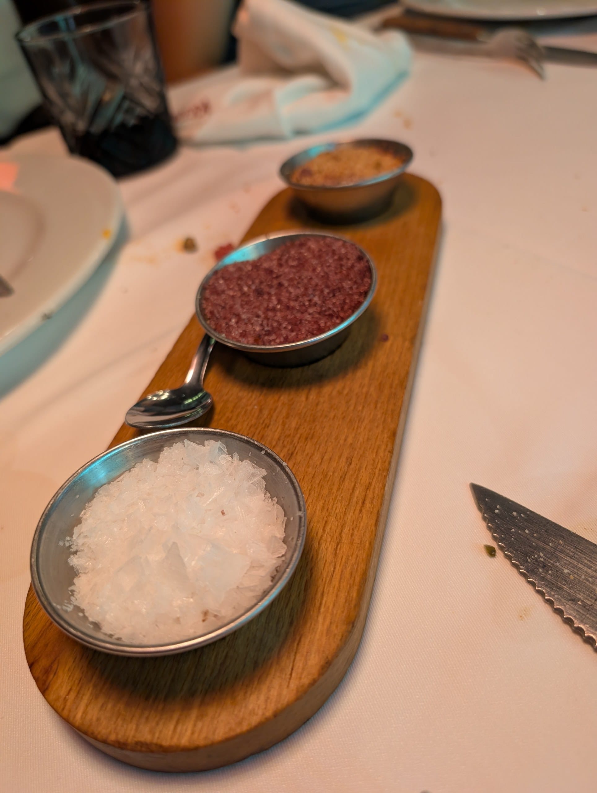 Three finishing salts on a wooden paddle served with the steak at La Cabrera Barcelona