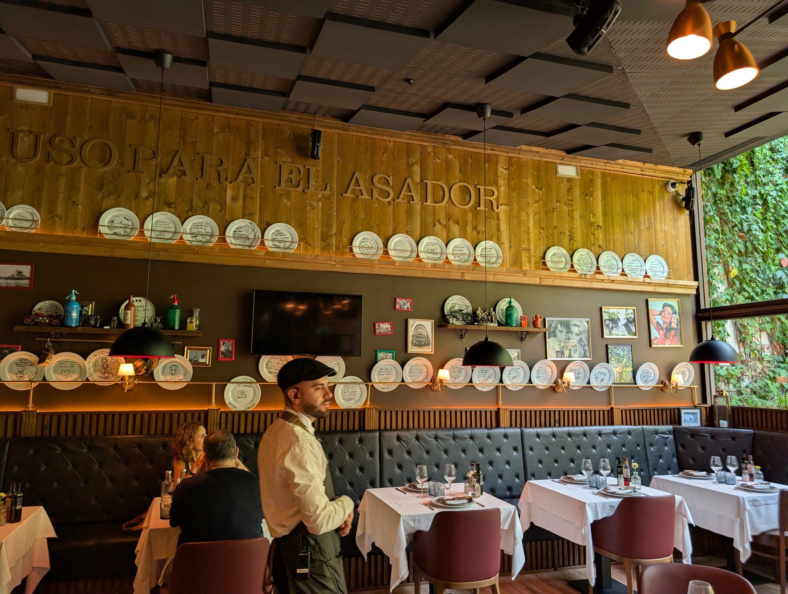 Rows of hand signed plates above the banquettes at La Cabrera Barcelona