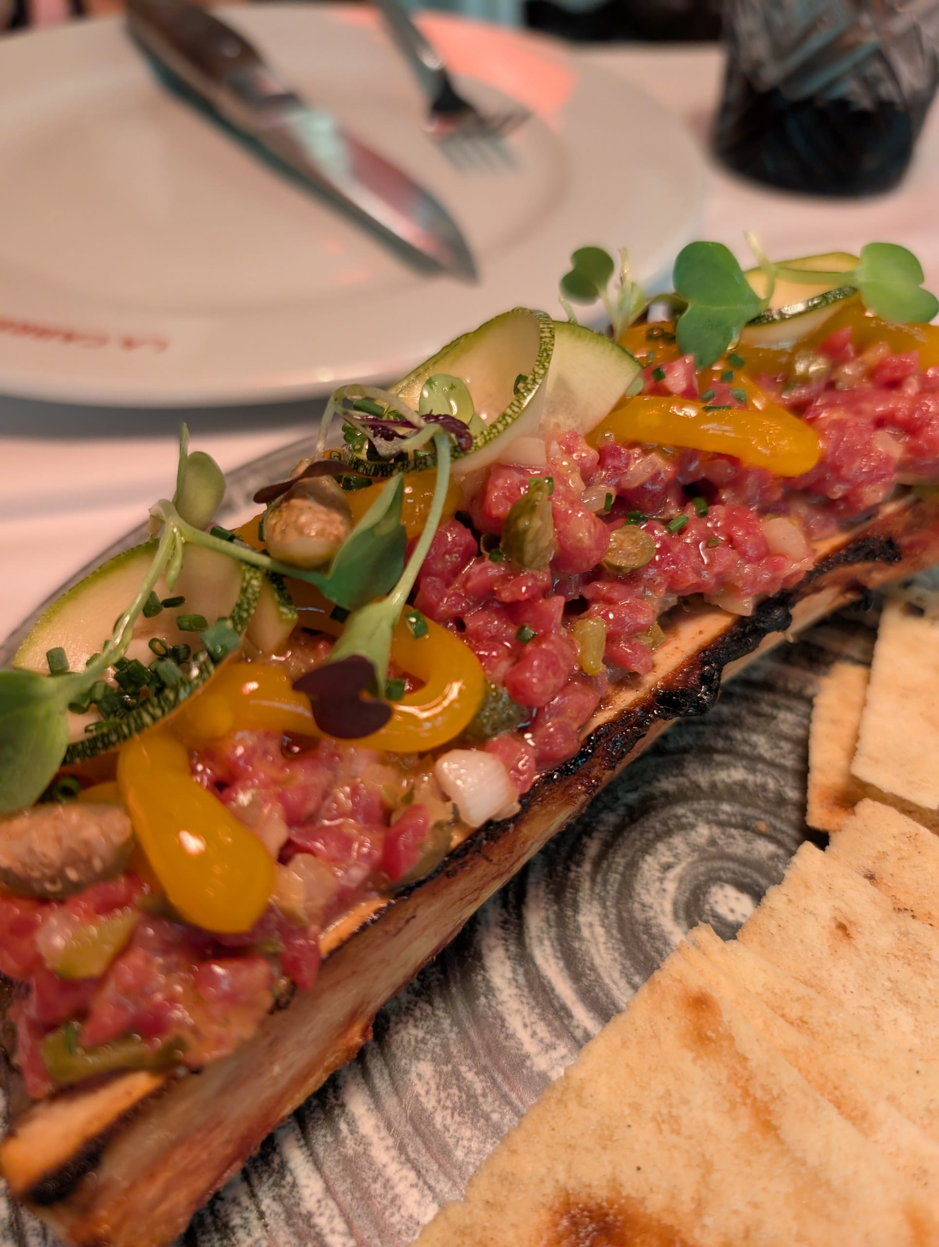 Steak tartare of Argentine sirloin served along a roasted split marrow bone at La Cabrera Barcelona