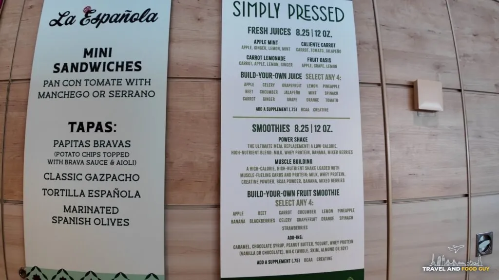 The La Espanola and Simply Pressed menu boards in the AquaDome Market, with fresh juices and smoothies priced at 8.25 for 12 ounces.