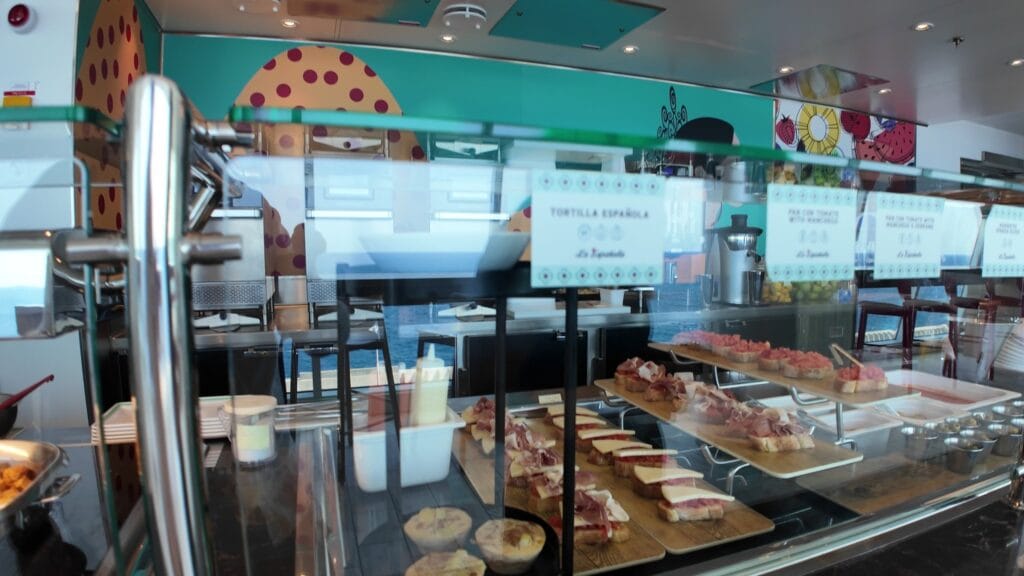 The La Espanola display case in the AquaDome Market, with pan con tomate boards, tortilla espanola and tapas laid out under glass.