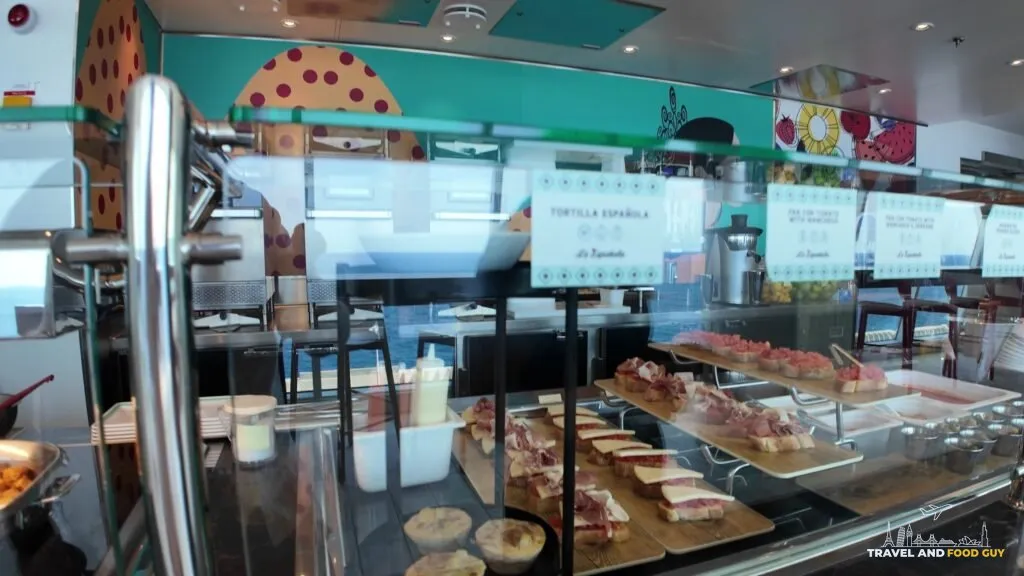 The La Espanola display case in the AquaDome Market, with pan con tomate boards, tortilla espanola and tapas laid out under glass.