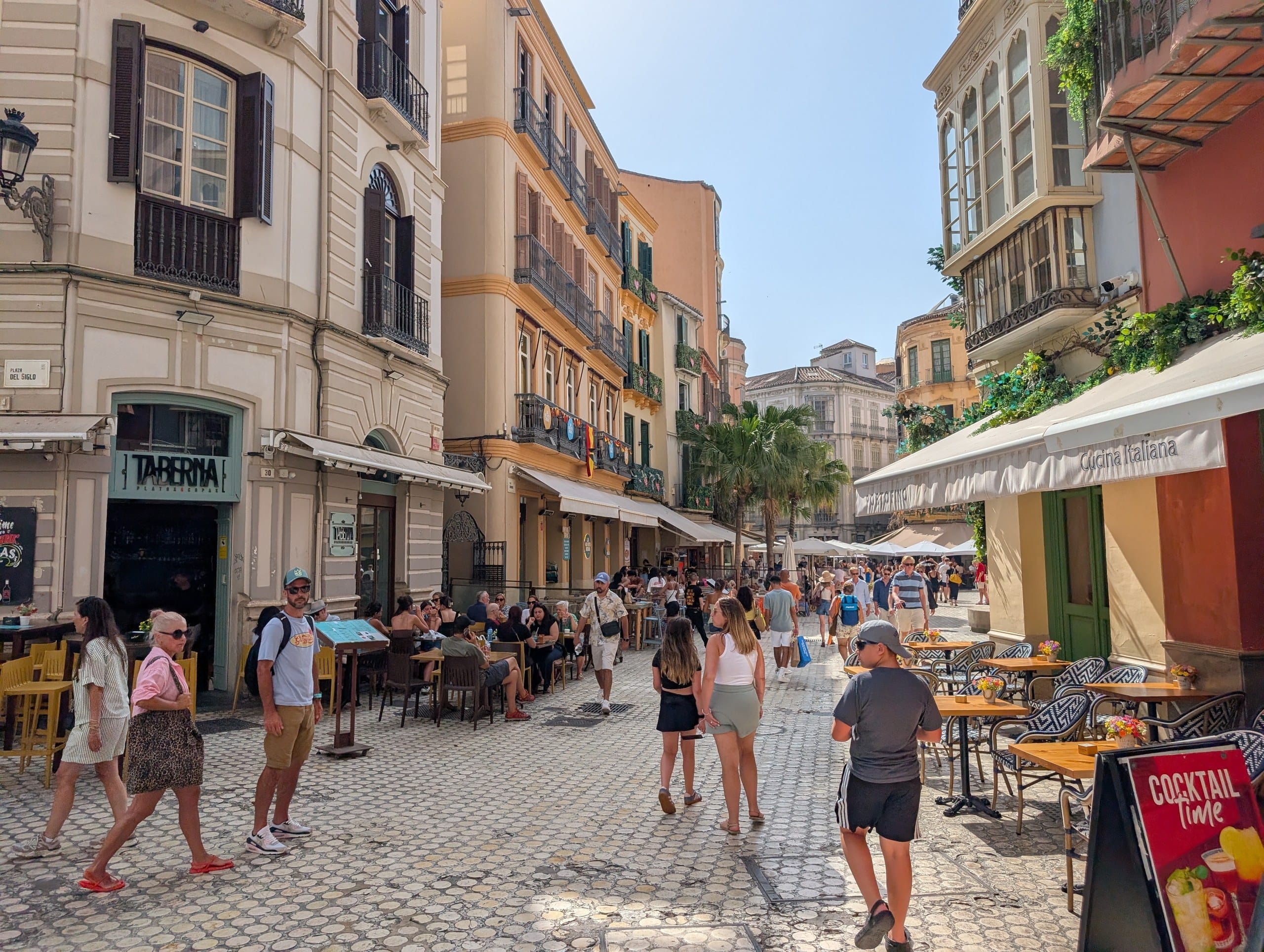 Busy pedestrian street in central Malaga lined with restaurant terraces