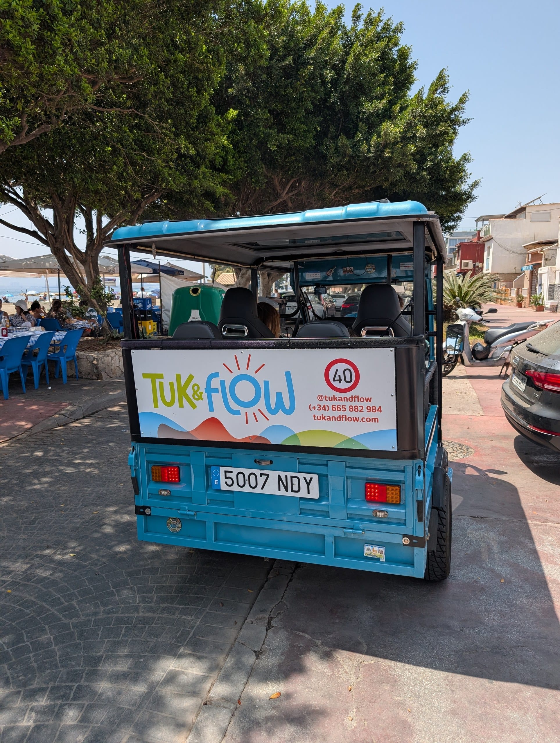 Blue Tuk and Flow electric tuk tuk parked on the seafront in Malaga