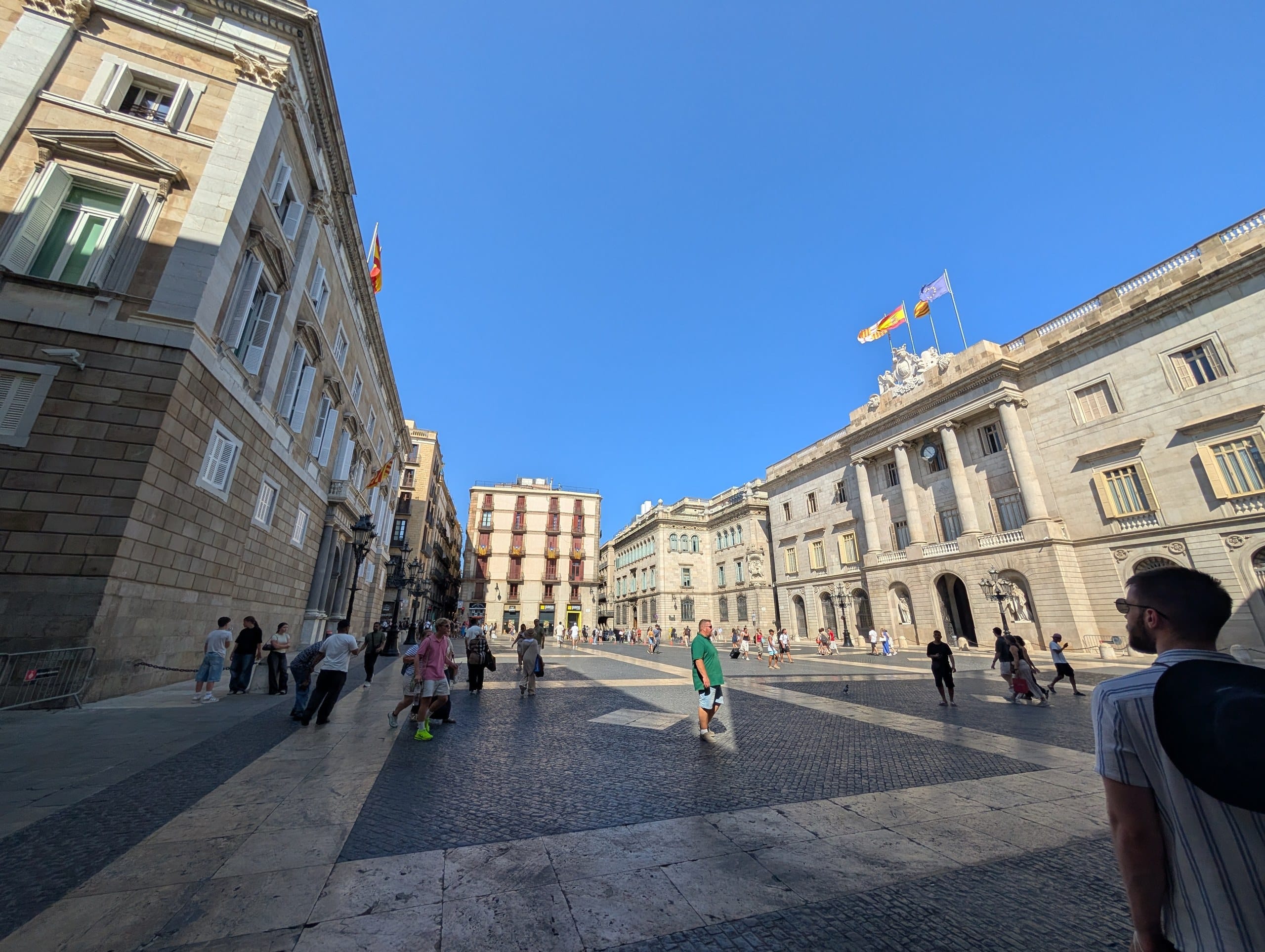 The open sunlit Placa Sant Jaume in Barcelona with the Generalitat and the city hall facing each other