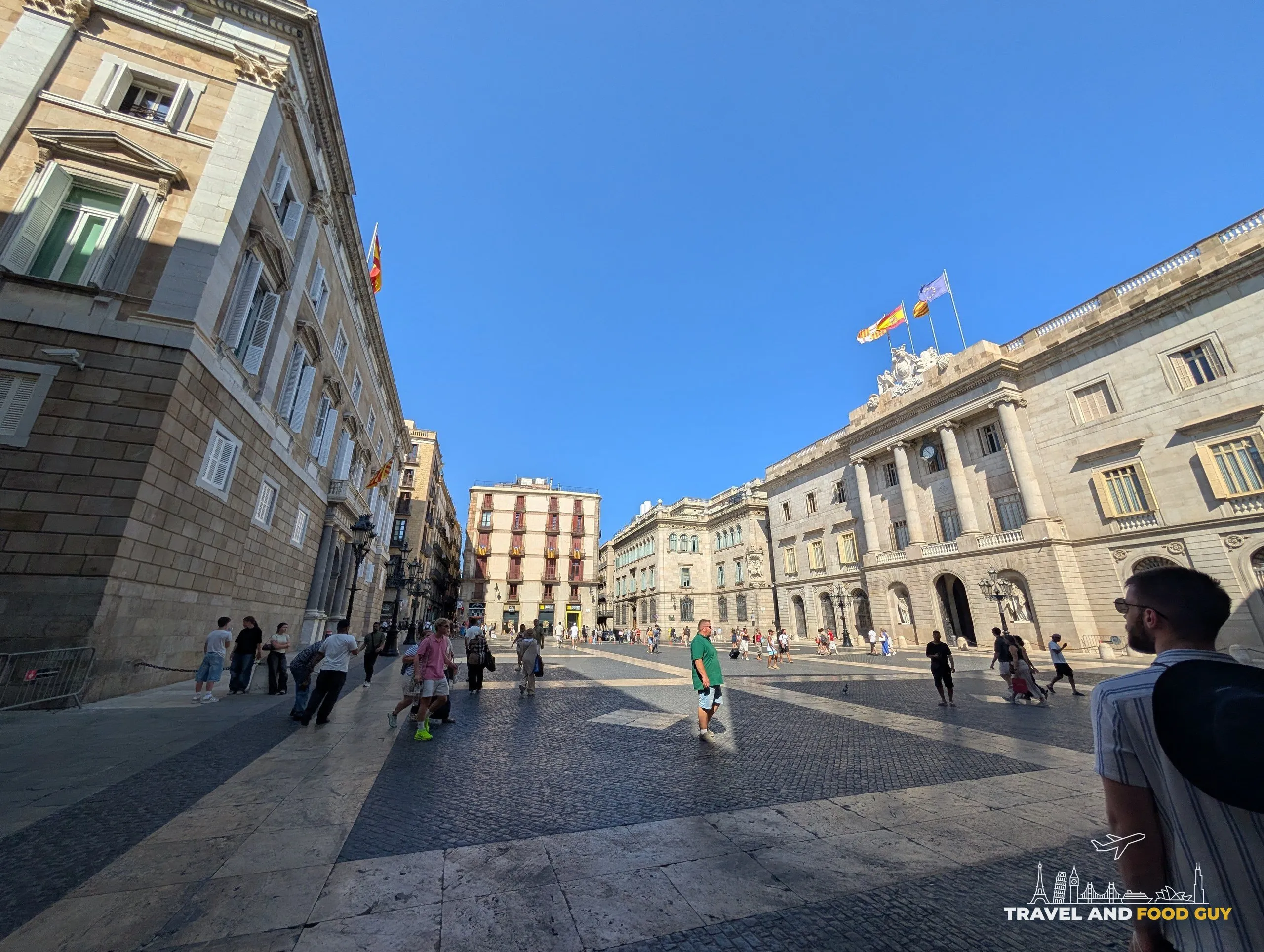 The open sunlit Placa Sant Jaume in Barcelona with the Generalitat and the city hall facing each other