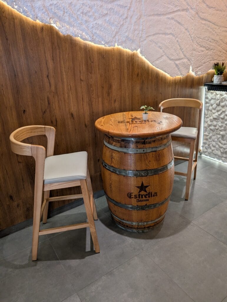 An Estrella Damm barrel table and stools inside Rincón Marino