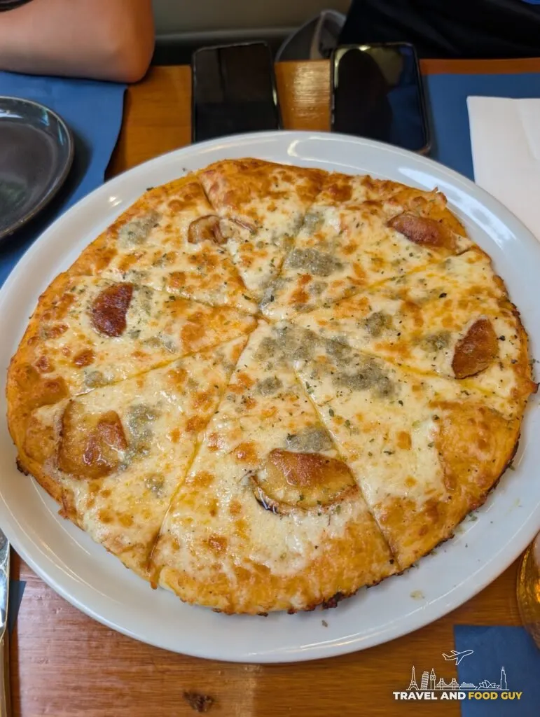 A four cheese pizza with a cheese pull at Rincón Marino