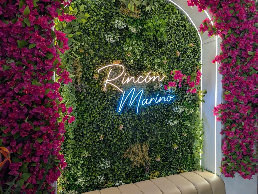 A greenery wall with neon lighting inside Rincón Marino in Barcelona