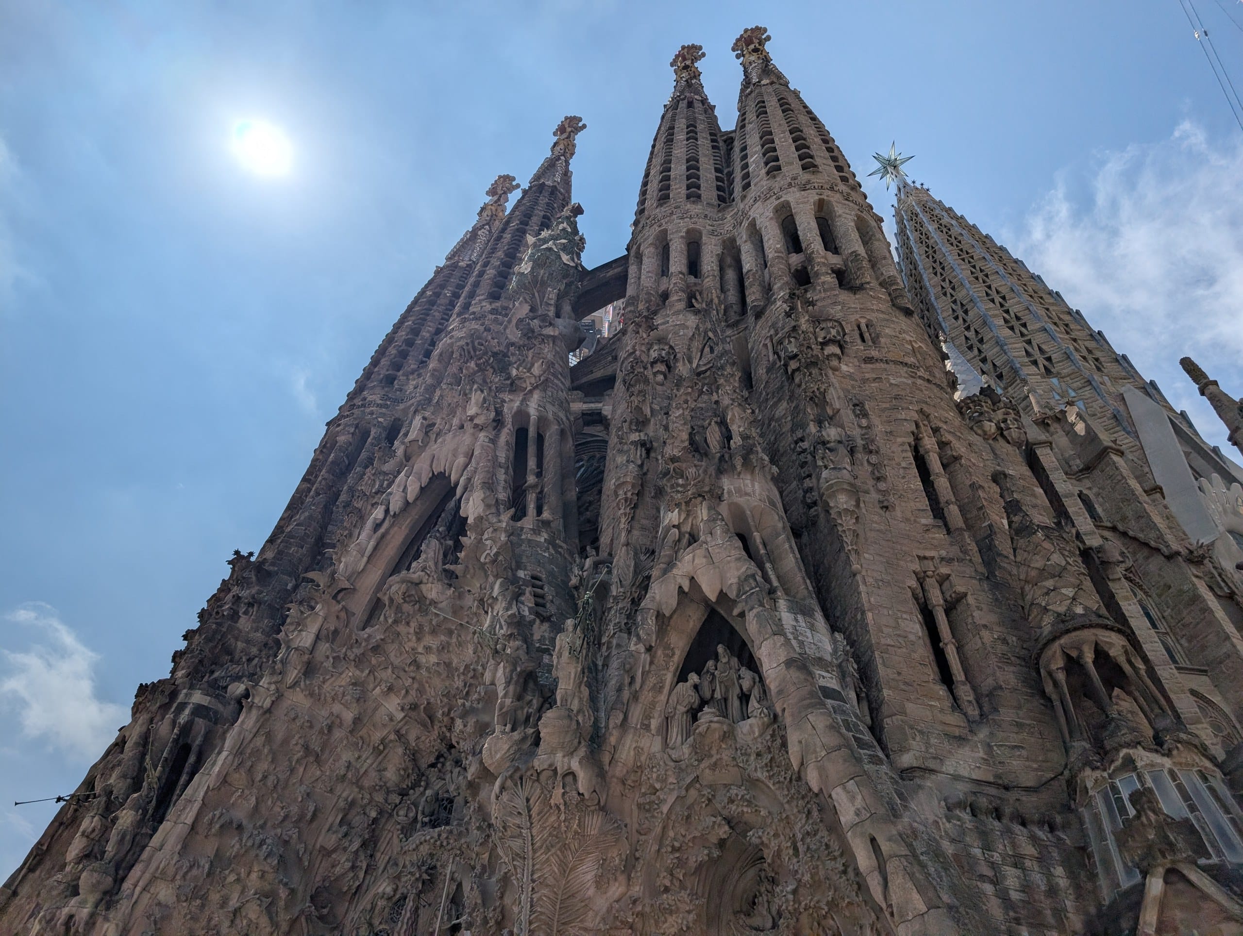 Sun flaring over the Sagrada Familia facade in August