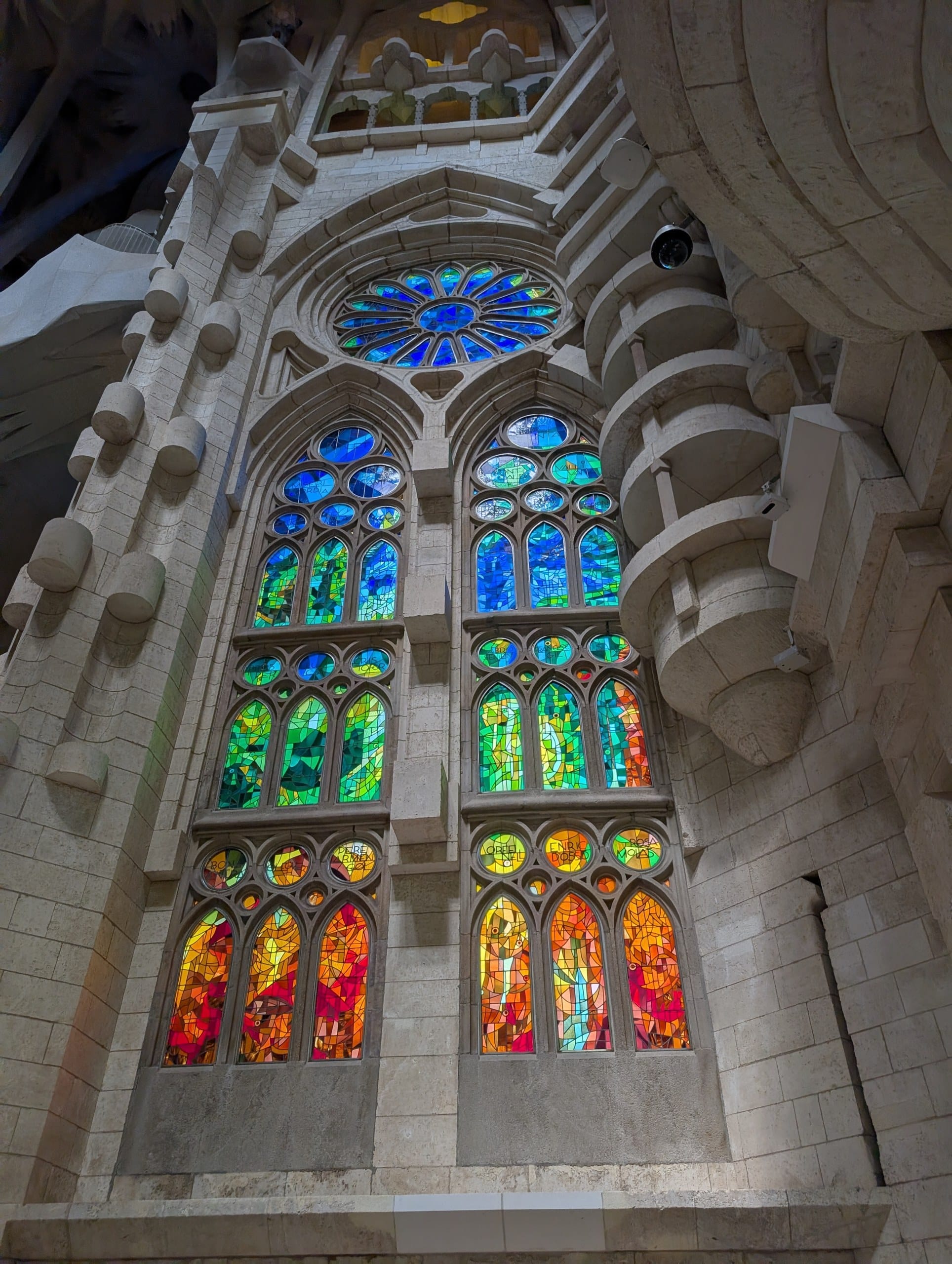 Cool blue and green stained glass on the Nativity side of the Sagrada Familia