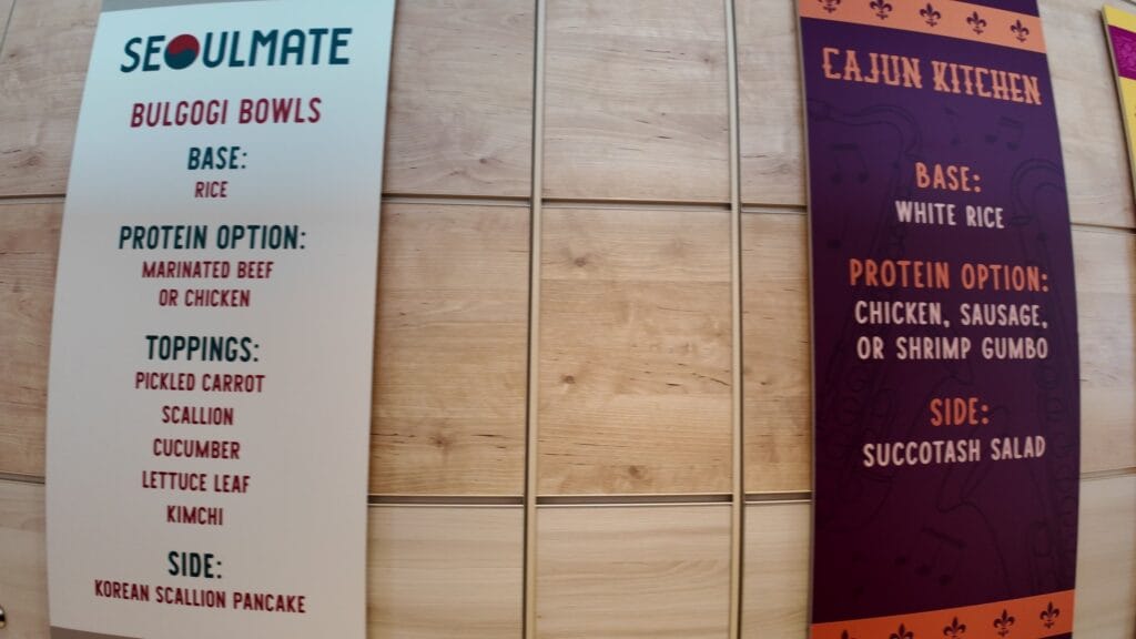 The Seoulmate and Cajun Kitchen menu boards in the AquaDome Market, listing bulgogi bowl toppings and the gumbo protein options.