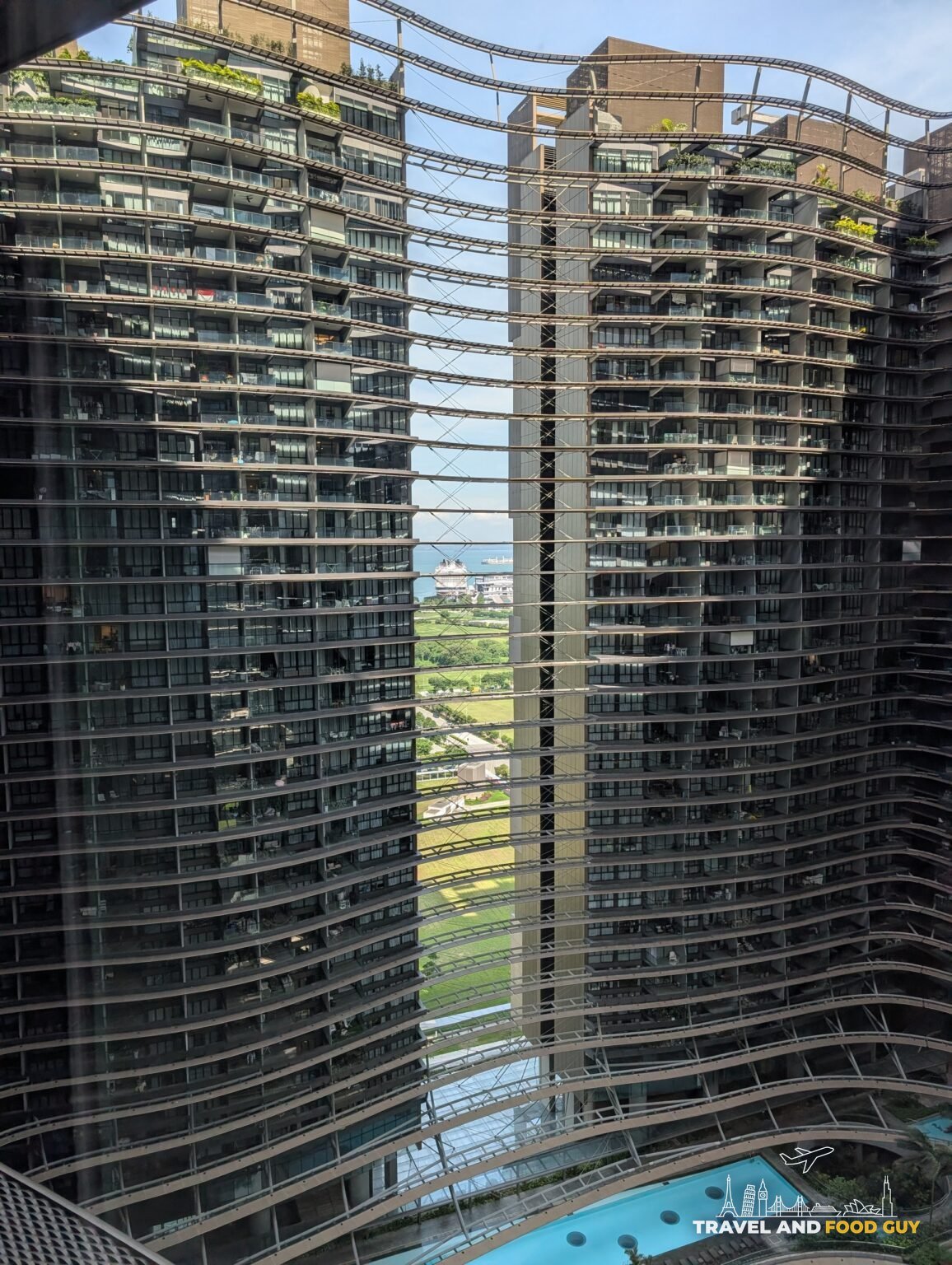 Looking out through the sinuous curtain-wall balconies of the Reflections at Keppel Bay condominium towers toward the port and greenery, Singapore