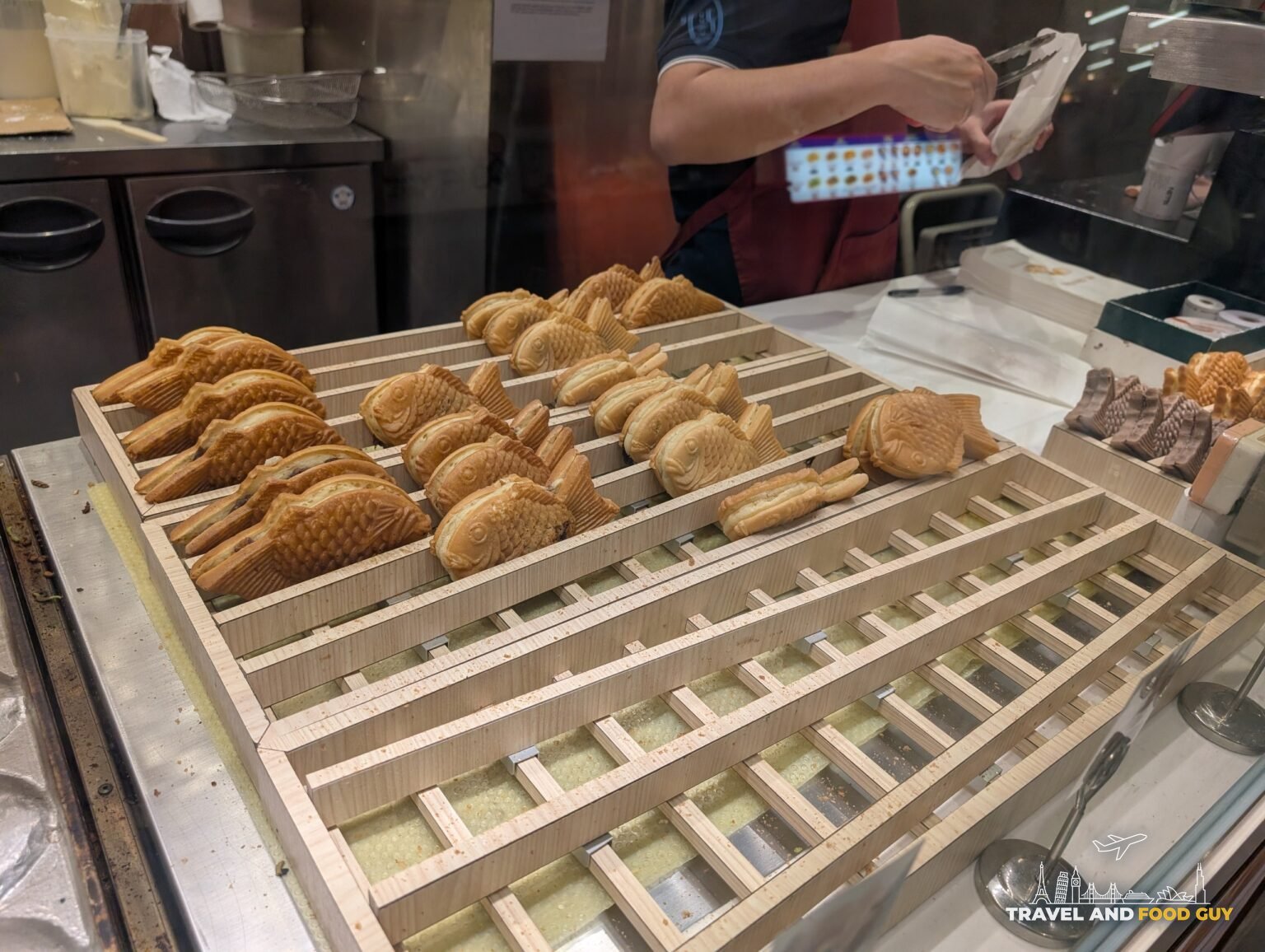 Rows of just-made taiyaki, the Japanese fish-shaped pastry filled with red bean or custard, cooling on a wooden rack