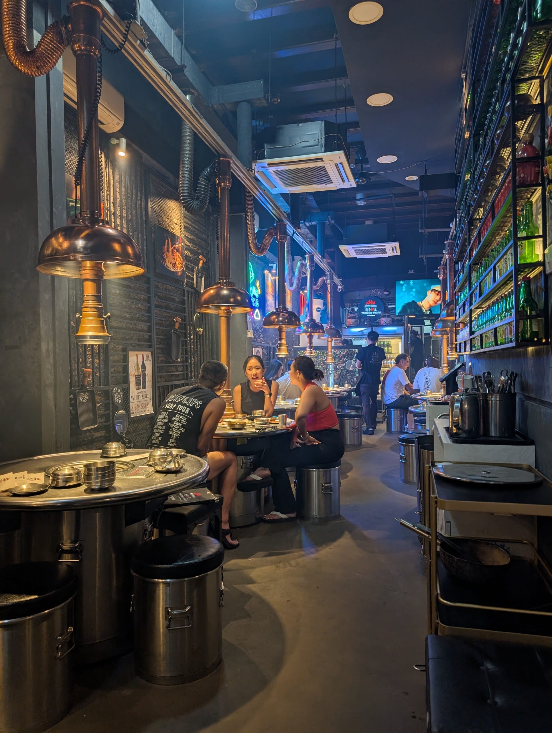 Tanjong Hwaro dining room, copper extractor hoods over drum tables