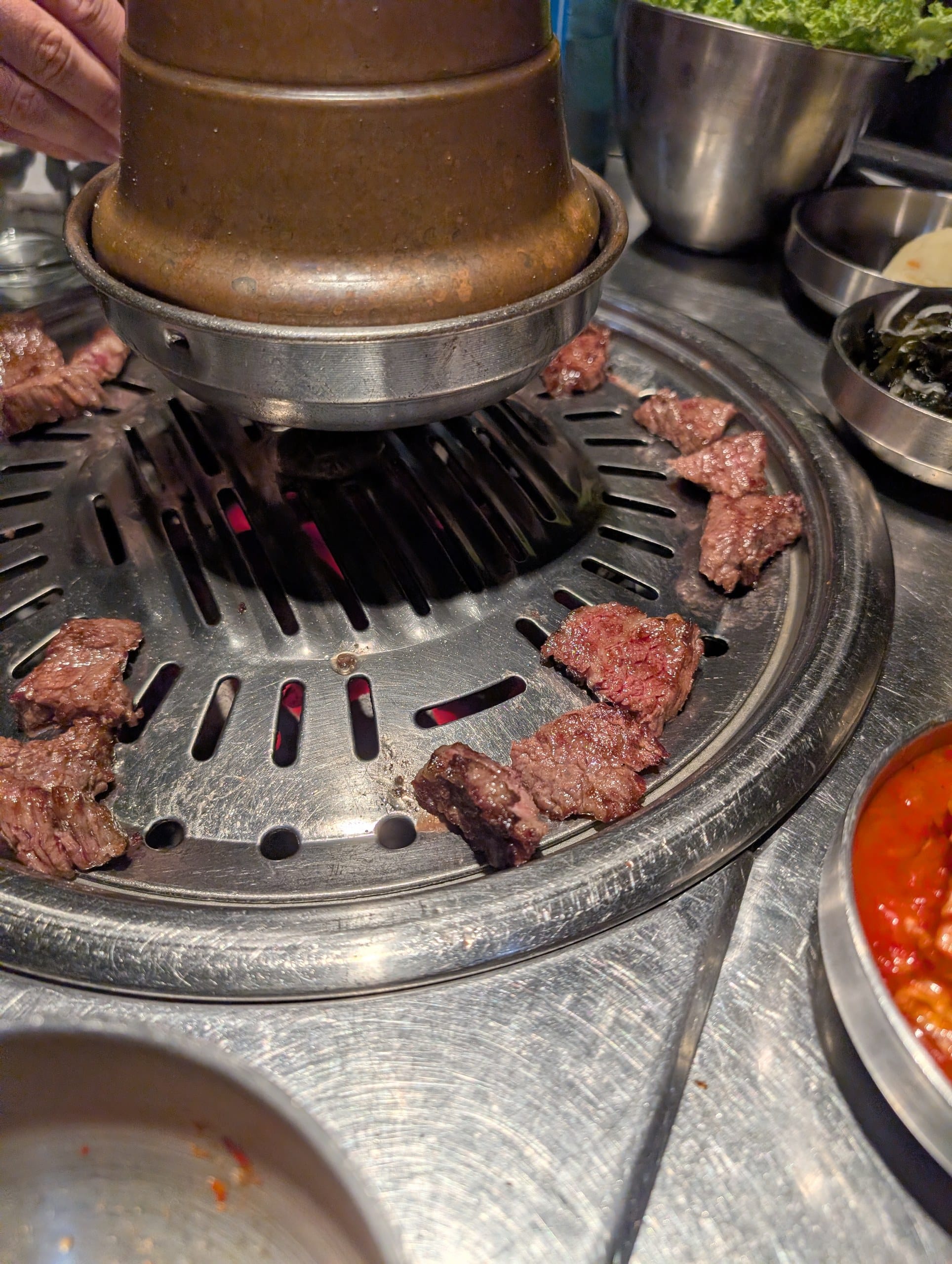 Meat cooking on the ring grill over live charcoal at Tanjong Hwaro