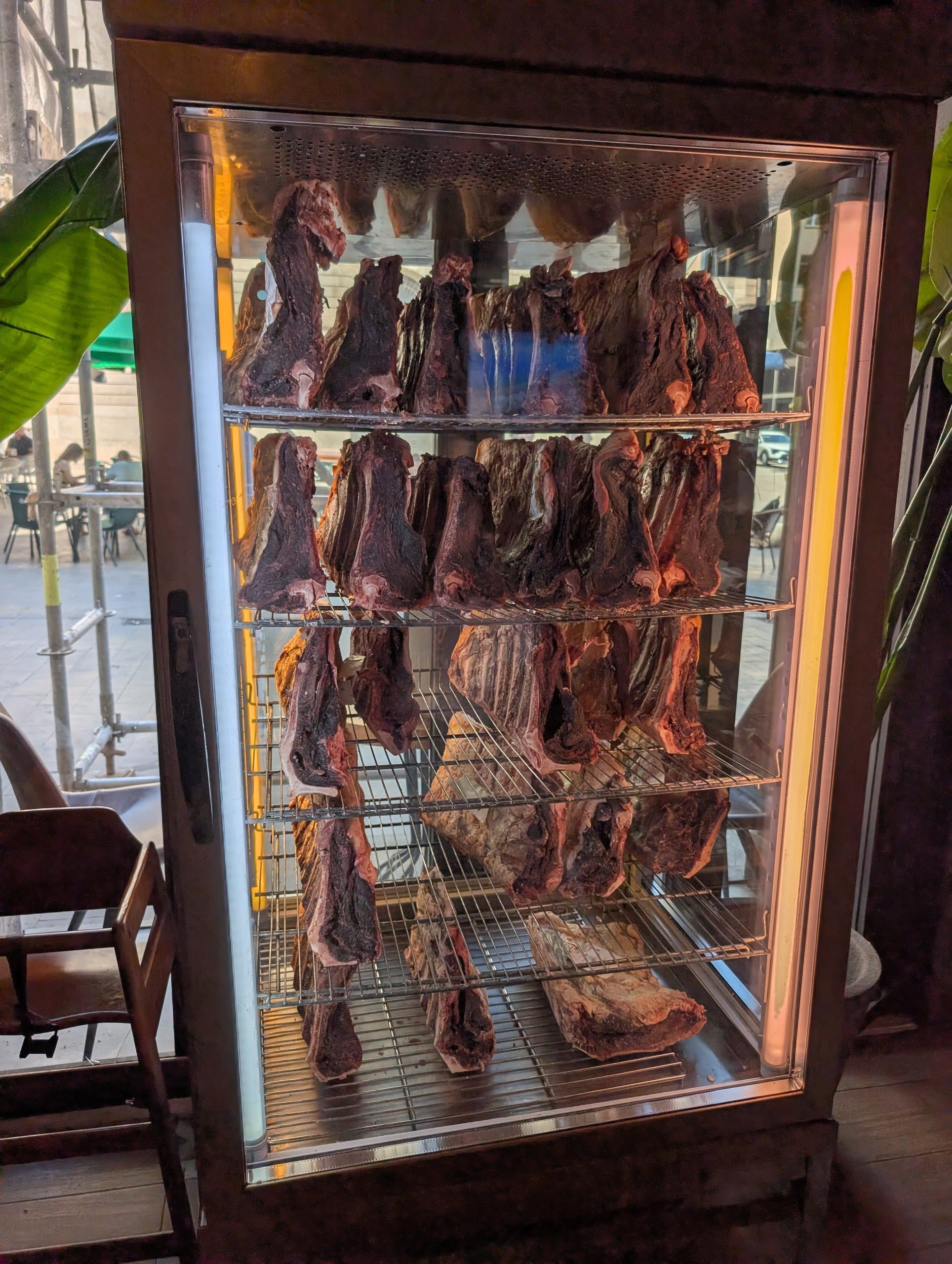 A glass fronted cabinet of aging beef inside Tapas San Miguel in Barcelona