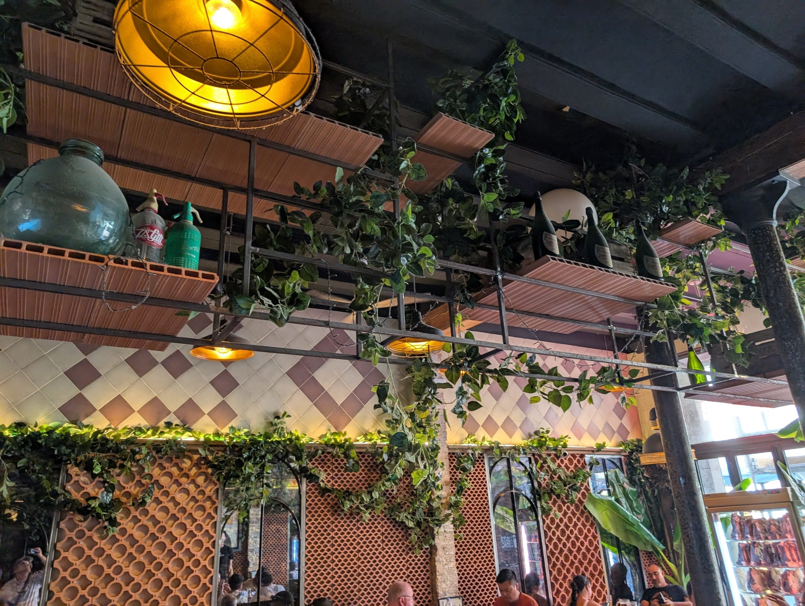 Hanging plants and tiled walls in the interior of Tapas San Miguel in Barcelona