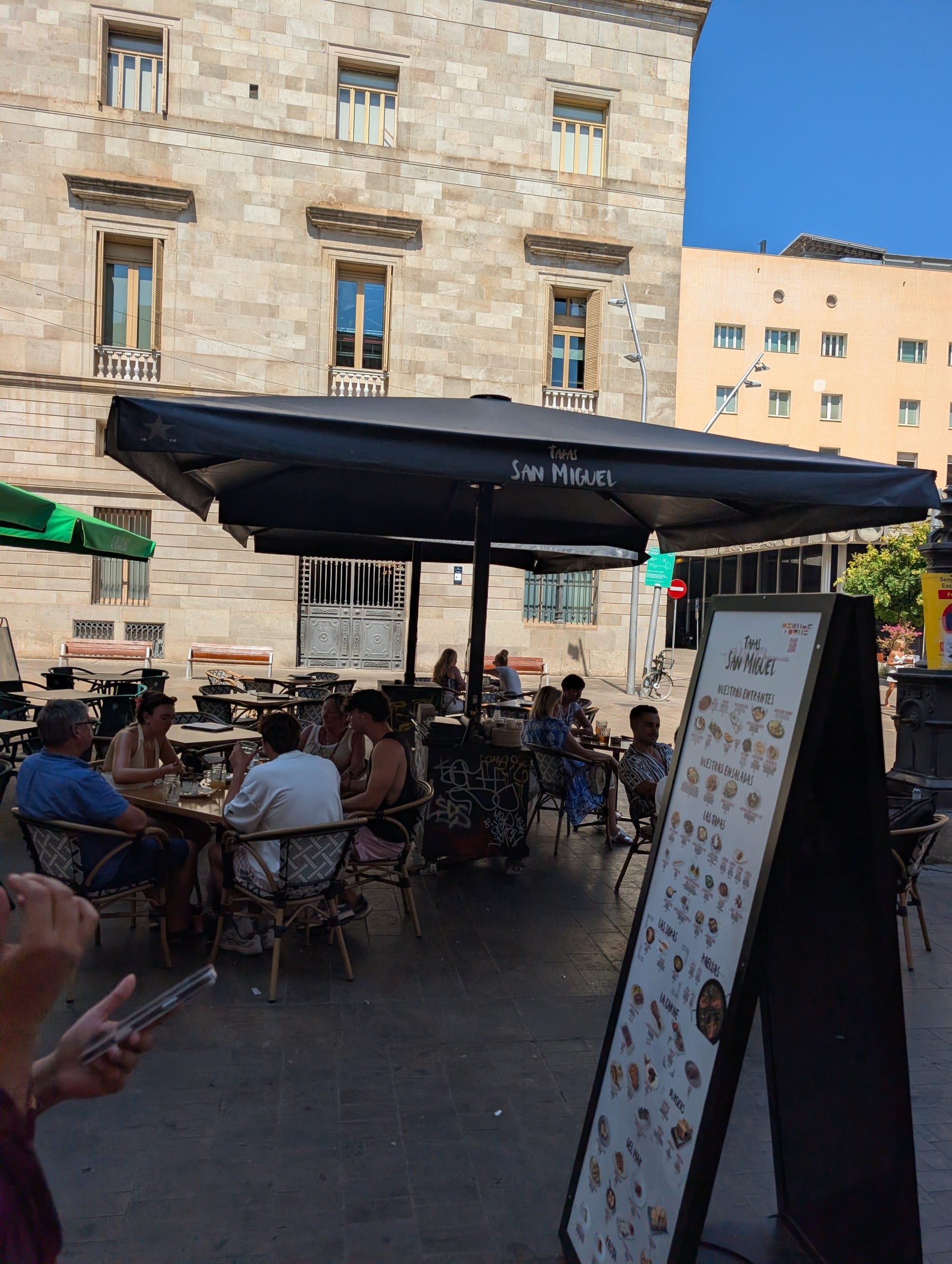 Terrace tables shaded by San Miguel branded parasols outside Tapas San Miguel in Barcelona