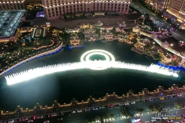 The Bellagio fountains lit up at night, seen from straight above on the Eiffel Tower viewing deck at Paris Las Vegas
