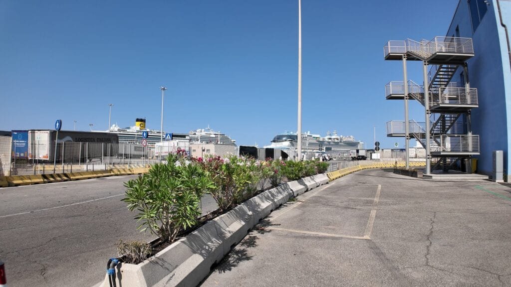 The signed pedestrian route through Civitavecchia port with cruise ships berthed beyond