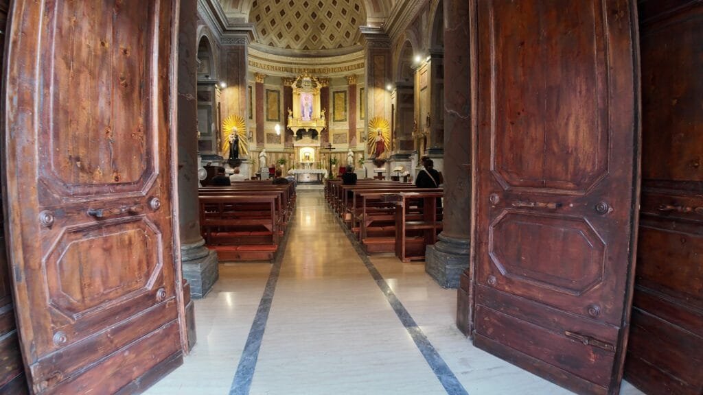 The nave and gilded altar of the Santuario della Santissima Concezione seen through its open doors