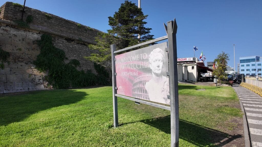 Billboard at Civitavecchia port reading Welcome to Civitavecchia, Port of Rome, with a Colosseum graphic