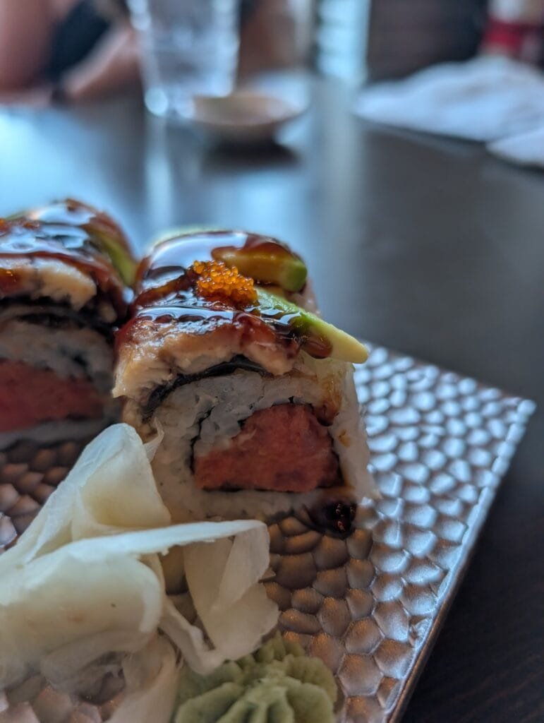 The fire dragon roll close up, eel and avocado on top with eel sauce and masago, spicy tuna inside.