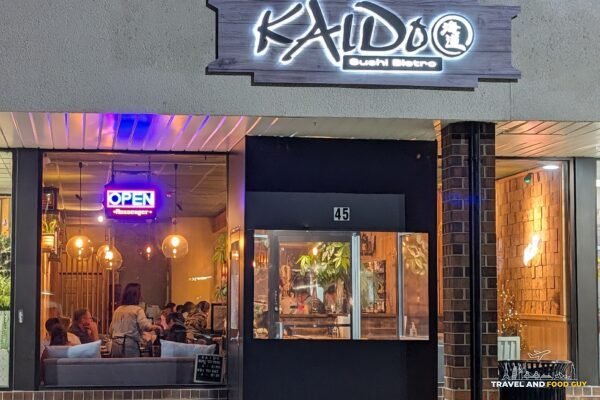 The Kaido Sushi Bistro sign over the front door, the dining room glowing through the windows.
