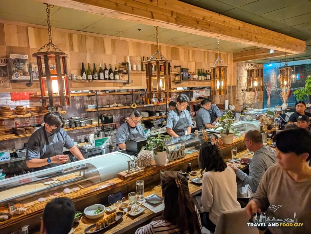 Sushi chefs working behind Kaido's bar while guests eat at the counter.