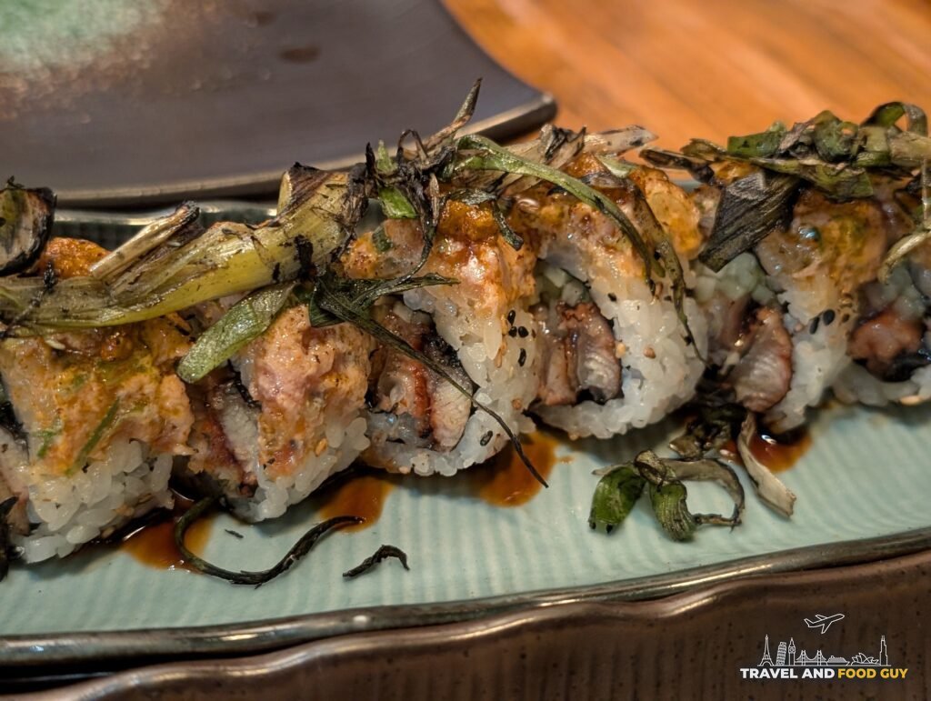 Kaido's Azure Dragon roll topped with charred scallion and eel sauce.